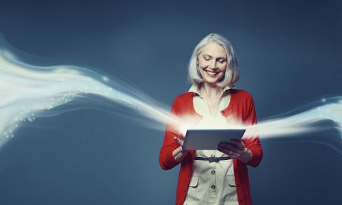 Composite image of senior woman standing with digital tablet with swirl of light rising from in
